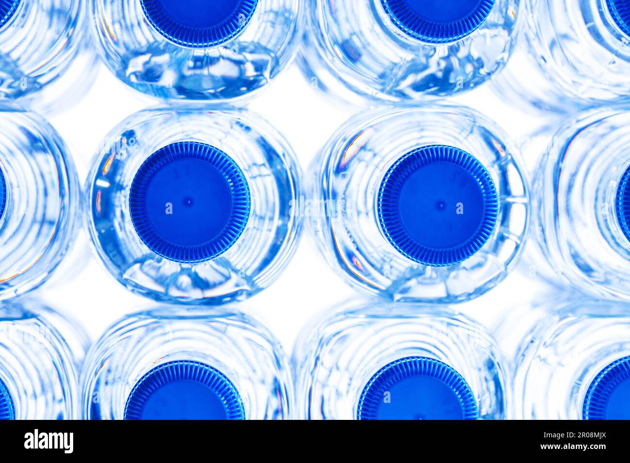 gruppo di piccole bottiglie d'acqua in plastica con tappo blu. Foto Stock