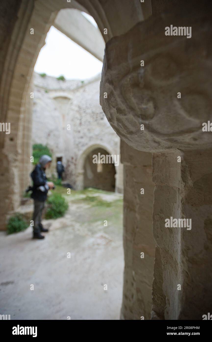 I visitatori esplorano una stanza con pietre storiche; antiche pietre in uno spazio storico poco illuminato. Chiesa di San Pantaleo, Martis, Sardegna, Italia Foto Stock