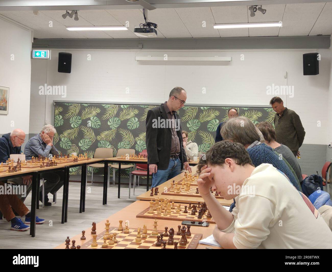 Zoetermeer, Paesi Bassi - 24 aprile 2023: Il nonno degli scacchi Erik van de Doel fa una partita di scacchi simultanea in un club di scacchi. Foto Stock