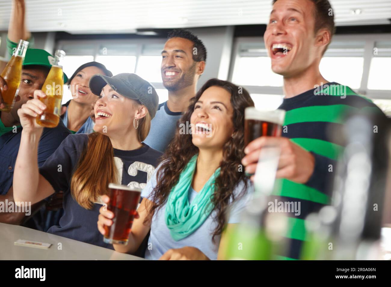 Porta su un altro round - ABBIAMO SEGNATO. Un gruppo di amici che allietano la loro squadra di sport preferita al bar. Foto Stock