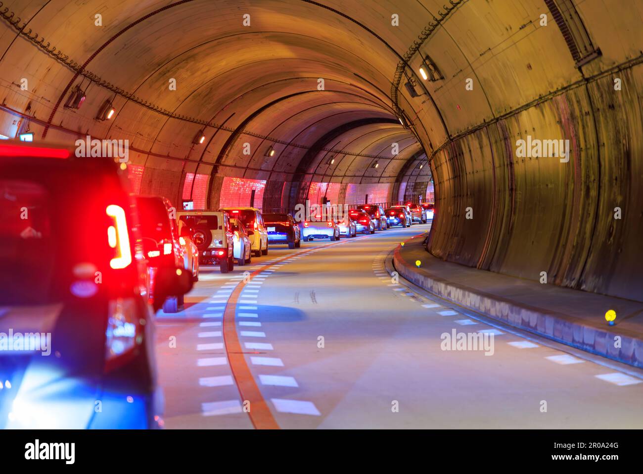 Linea di vetture ferma in forte traffico in galleria curva Foto Stock