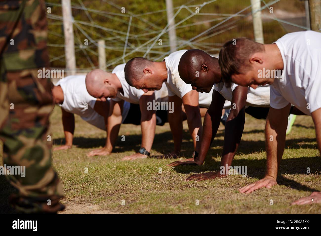 Un gruppo di uomini che fanno delle "push-up" in un bootcamp militare. Foto Stock