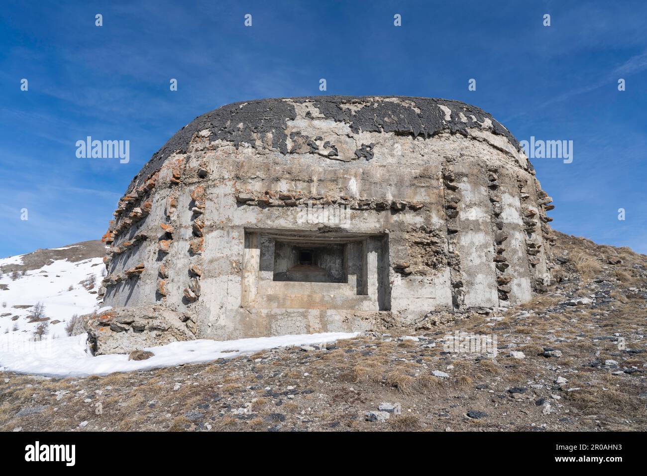 Una vista del bunker della guerra mondiale sulla cima della montagna innevata nelle Alpi italiane. Rovine di un'antica fortezza Foto Stock
