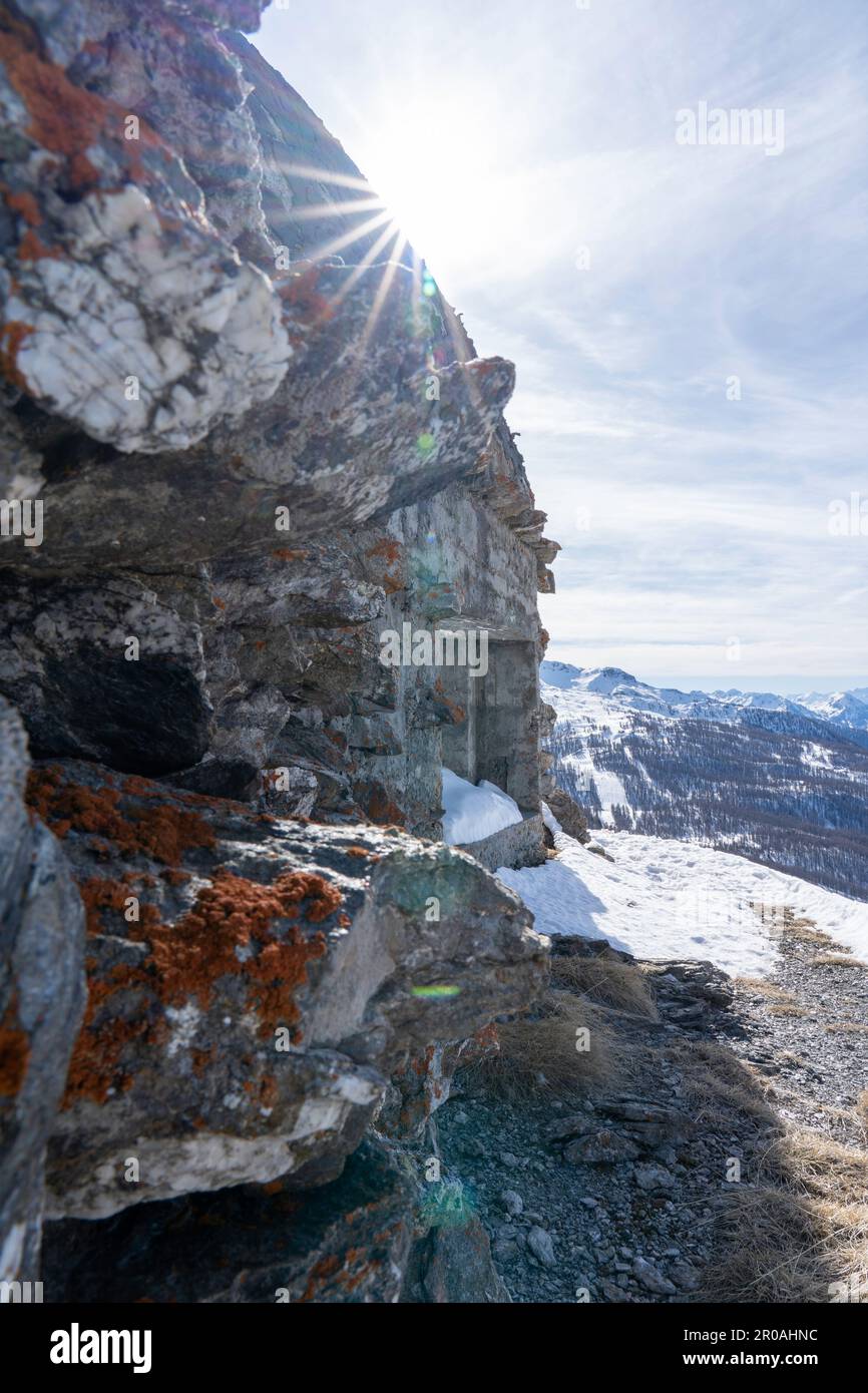 Una vista del bunker della guerra mondiale sulla cima della montagna innevata nelle Alpi italiane. Rovine di un'antica fortezza Foto Stock