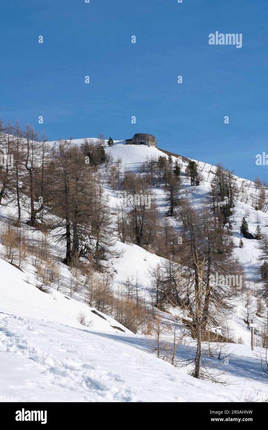 Una vista del bunker della guerra mondiale sulla cima della montagna innevata nelle Alpi italiane. Rovine di un'antica fortezza Foto Stock