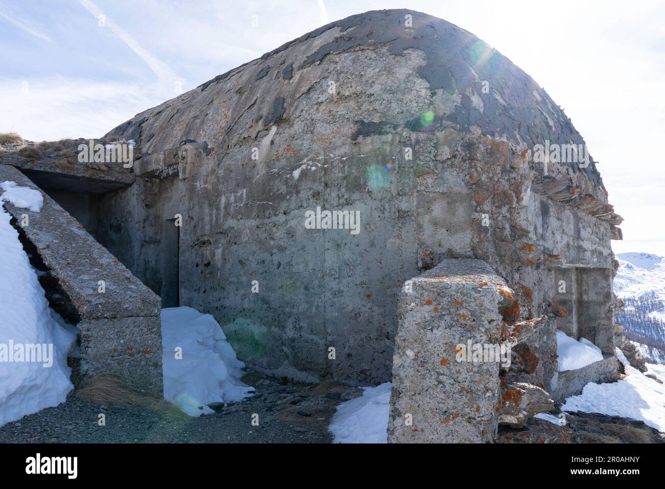 Una vista del bunker della guerra mondiale sulla cima della montagna innevata nelle Alpi italiane. Rovine di un'antica fortezza Foto Stock