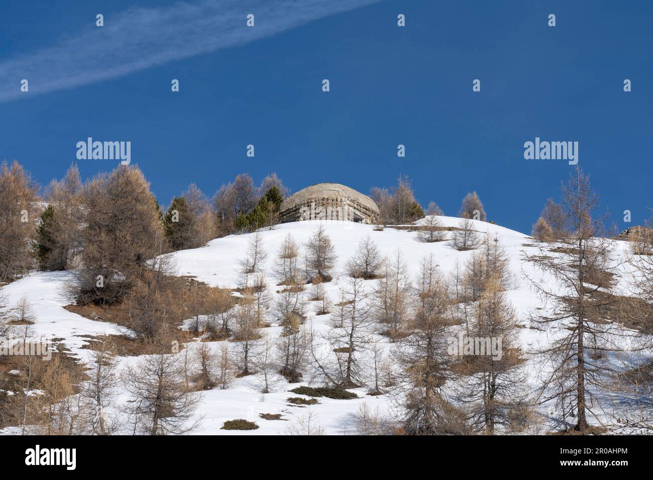 Una vista del bunker della guerra mondiale sulla cima della montagna innevata nelle Alpi italiane. Rovine di un'antica fortezza Foto Stock