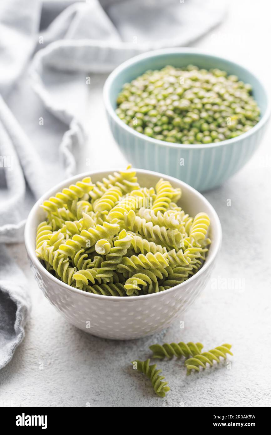 Fusilli di fagiolo di Mung. Ciotola con pasta cruda e fagiolo verde. Pasta senza glutine. Foto Stock