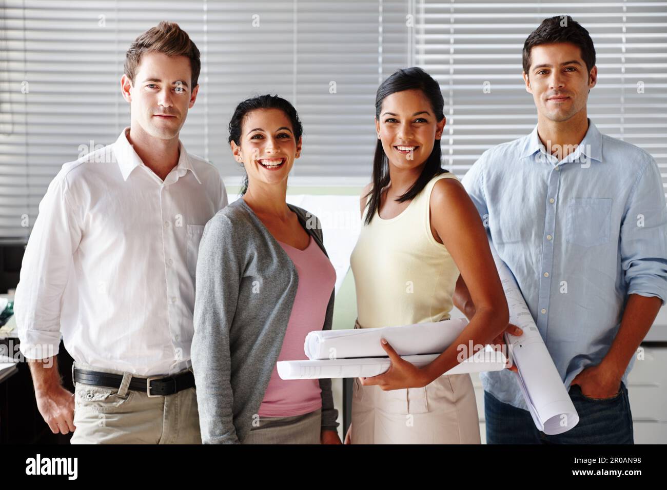Team di architetti di successo. Un team sicuro di architetti sorridenti mentre si tengono progetti. Foto Stock