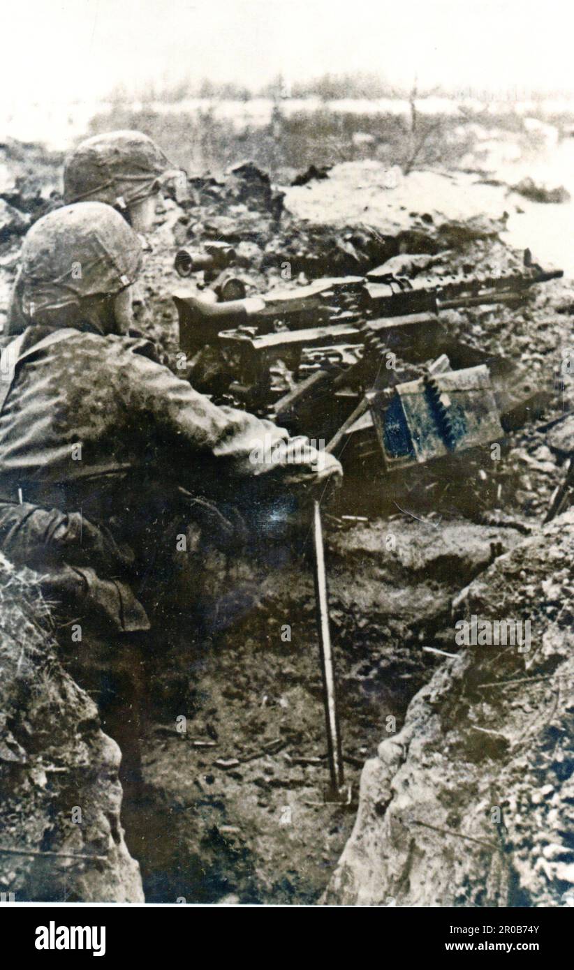Seconda guerra mondiale foto B&W soldati tedeschi delle Waffen SS in trincea con una pistola pesante . Gli uomini sono della SS Mountain Division Nord, parte del gruppo d'armate Nord Foto Stock
