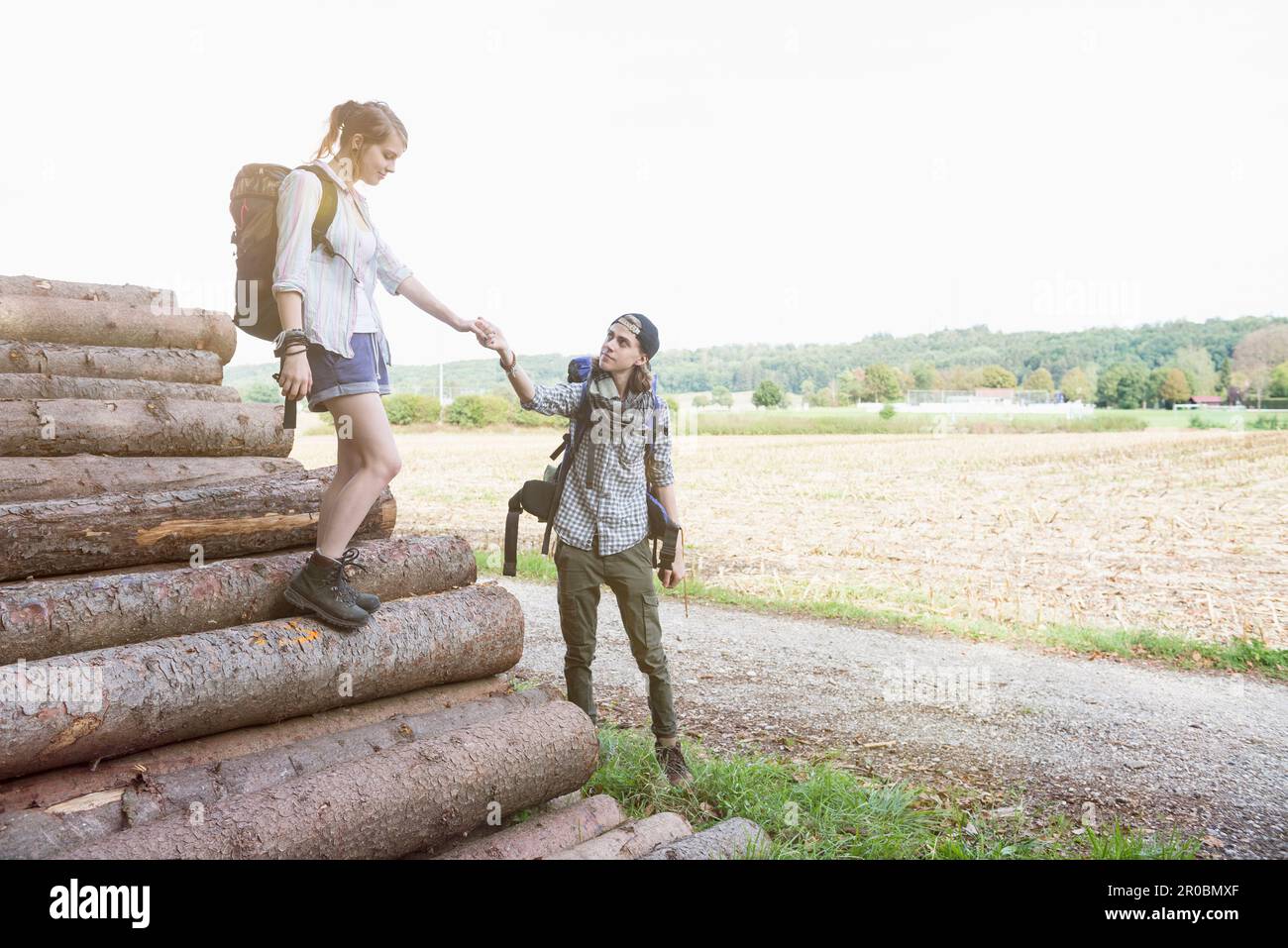 Giovane coppia che si prepara a continuare la loro escursione su palo di legno, Baviera, Germania Foto Stock