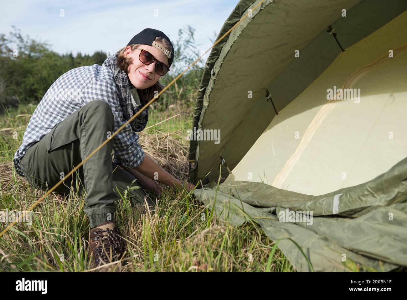 Ragazzo adolescente che allestiscono una tenda per campeggio, Baviera, Germania Foto Stock