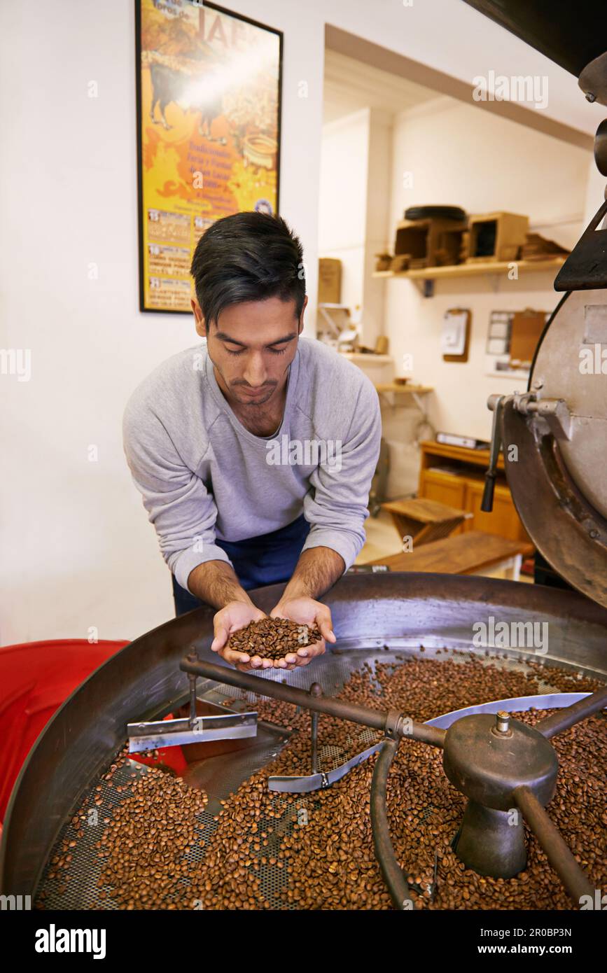 Ahhh, la tostatura perfetta. una macchina per macinare e tostare i chicchi di caffè. Foto Stock