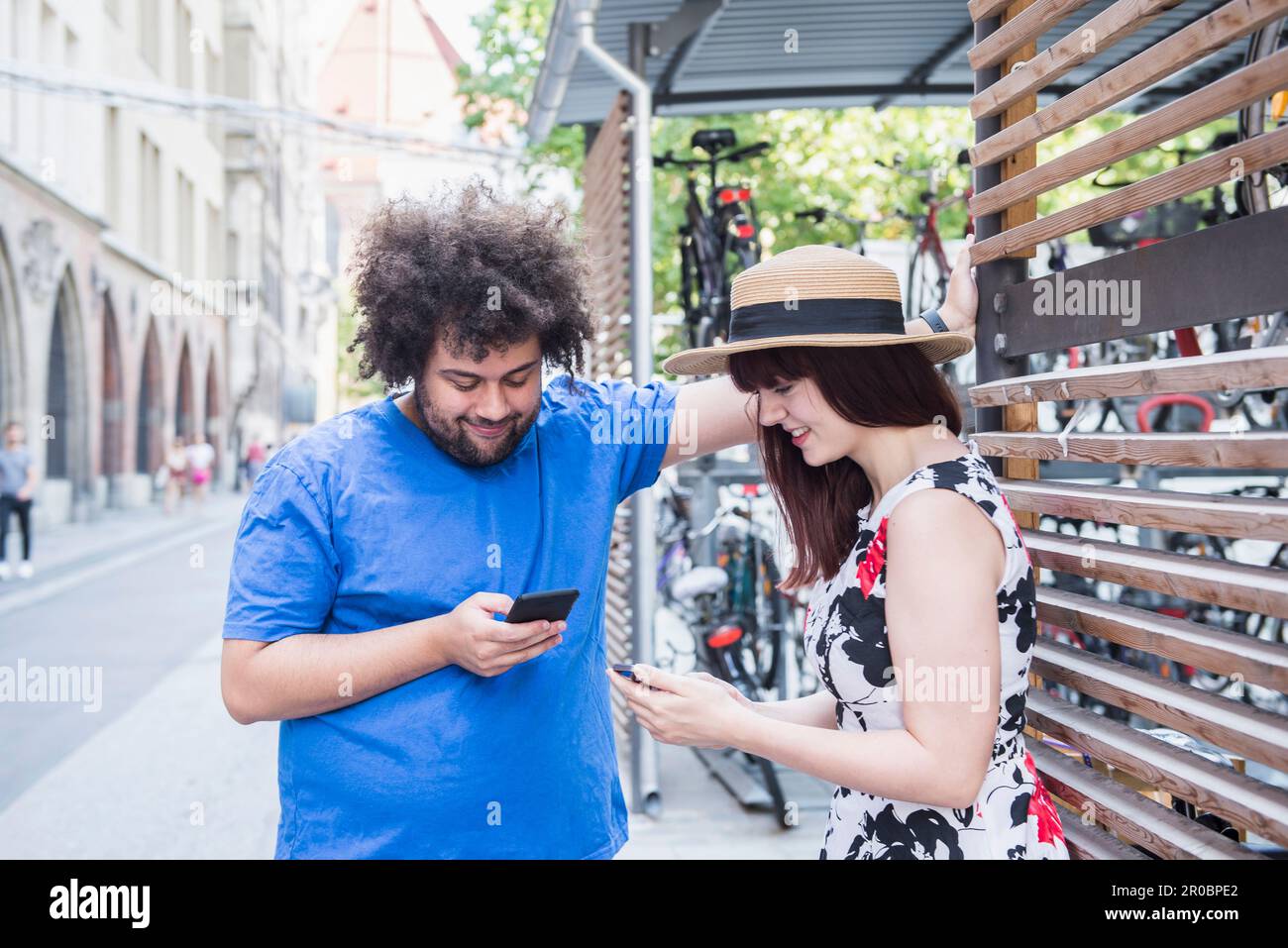 Messaggi di testo per giovani coppie sul telefono cellulare in città Foto Stock