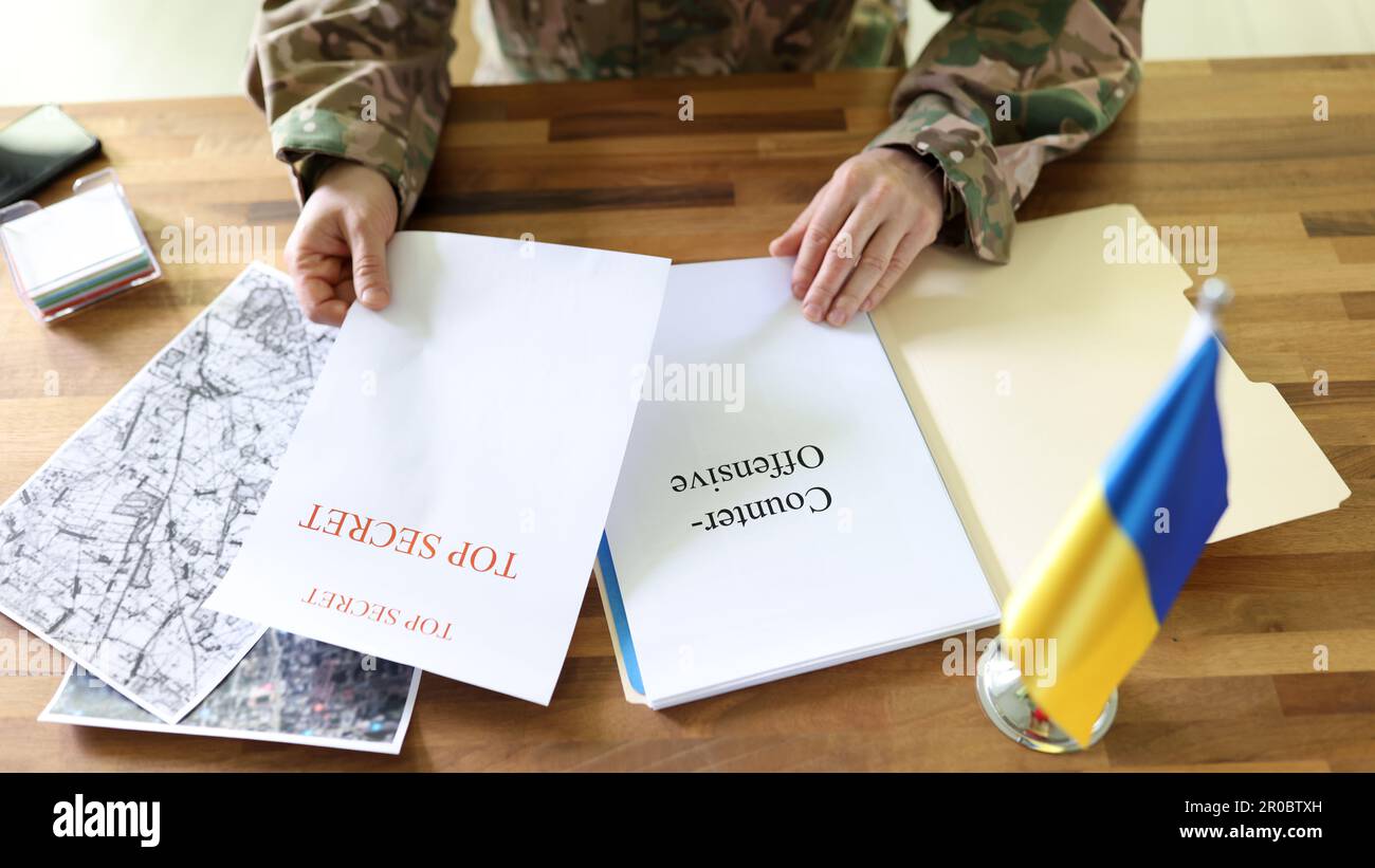Uomo militare che tiene in mano piani segreti di operazione Ucraina controffensiva Foto Stock