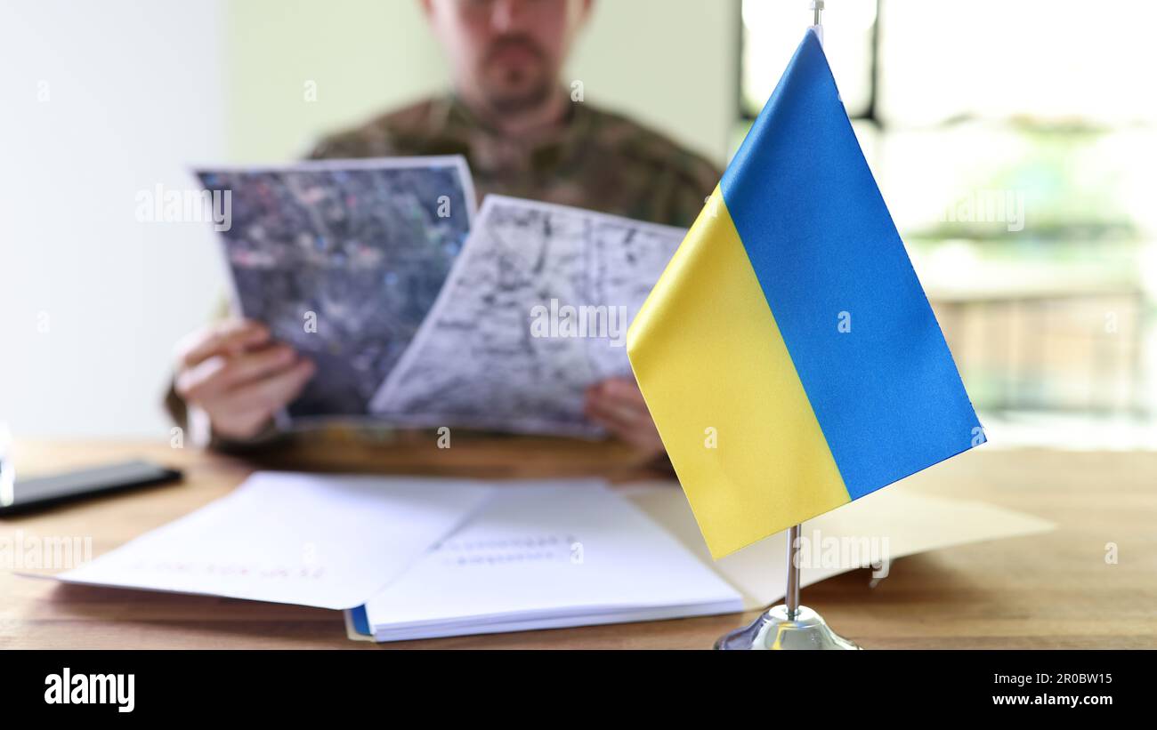 L'uomo militare che tiene in mano piani segreti di operazioni controffensive ucraine closeup Foto Stock