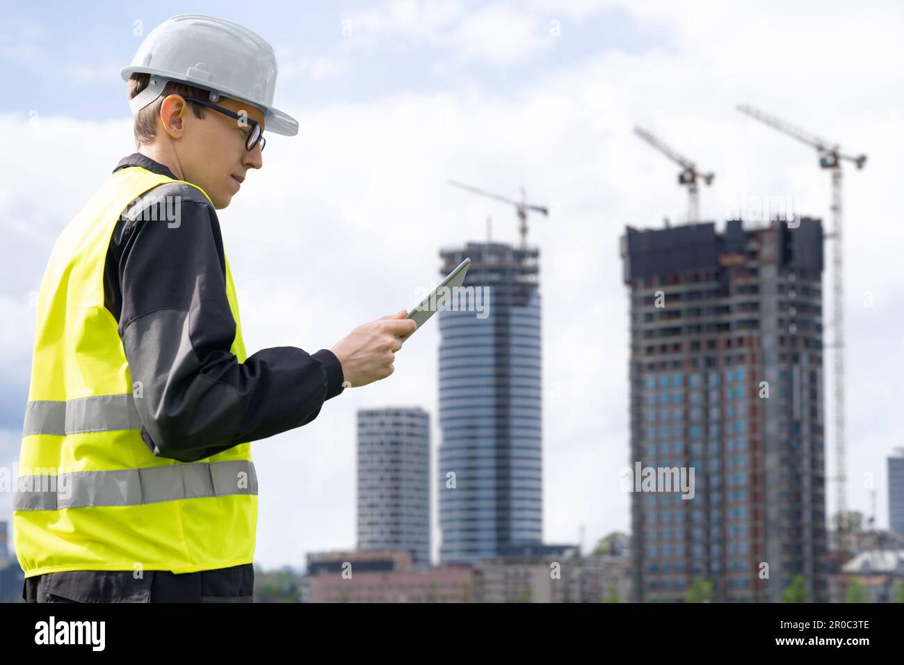 Progettare con un tablet digitale sullo sfondo di un edificio in costruzione. Foto di alta qualità Foto Stock
