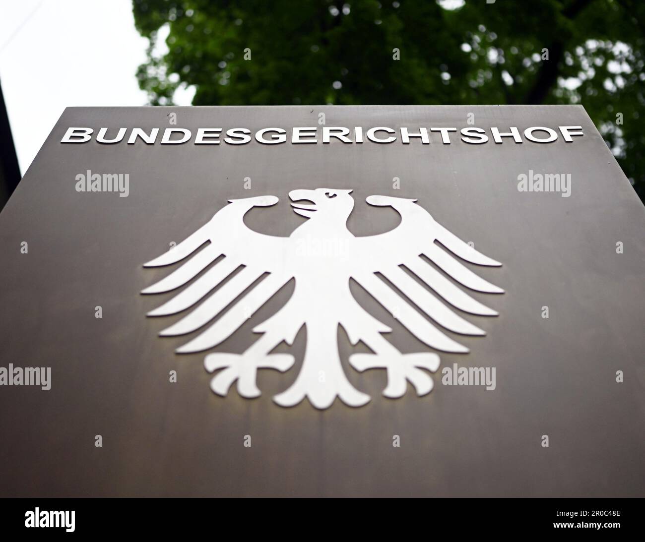 Karlsruhe, Germania. 08th maggio, 2023. Un cartello con un'aquila federale e la scritta Bundesgerichtshof, davanti al Bundesgerichtshof (BGH). Tramite. Il Senato civile sta sentendo casi di gasolio. Tre anni dopo la sua prima sentenza sullo scandalo del gasolio, la BGH si trova nuovamente di fronte a una decisione importante. Il motivo è una sentenza della Corte di giustizia europea (CGCE) del mese di marzo. Nella sentenza, i giudici lussemburghesi hanno fissato gli ostacoli per i danni significativamente più bassi dei loro omologhi tedeschi. Credit: Uli Deck/dpa/Alamy Live News Foto Stock
