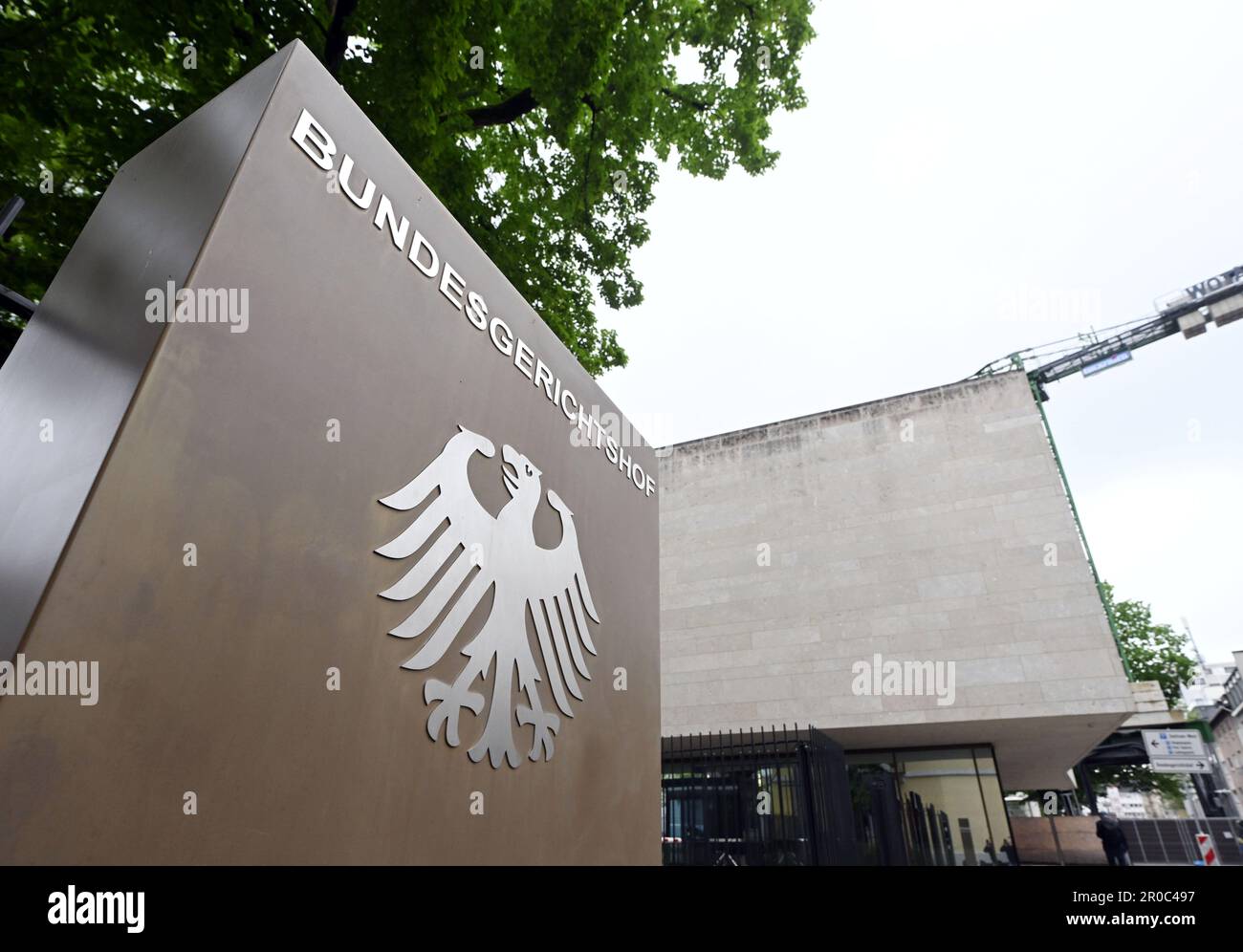 Karlsruhe, Germania. 08th maggio, 2023. Un cartello con un'aquila federale e la scritta Bundesgerichtshof, davanti al Bundesgerichtshof (BGH). Tramite. Il Senato civile sta sentendo casi di gasolio. Tre anni dopo la sua prima sentenza sullo scandalo del gasolio, la BGH si trova nuovamente di fronte a una decisione importante. Il motivo è una sentenza della Corte di giustizia europea (CGCE) del mese di marzo. Nella sentenza, i giudici lussemburghesi hanno fissato gli ostacoli per i danni significativamente più bassi dei loro omologhi tedeschi. Credit: Uli Deck/dpa/Alamy Live News Foto Stock