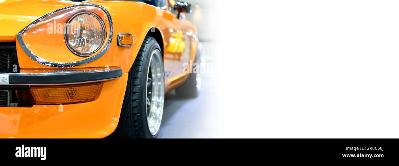 Dettaglio fari anteriori di auto classica arancione, sfondo bianco, lato banner, spazio copia Foto Stock