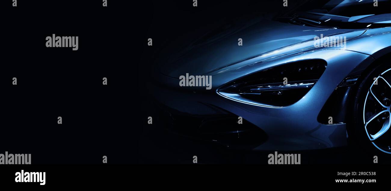 Dettaglio fari anteriori di super auto blu tono su sfondo nero, copia spazio Foto Stock