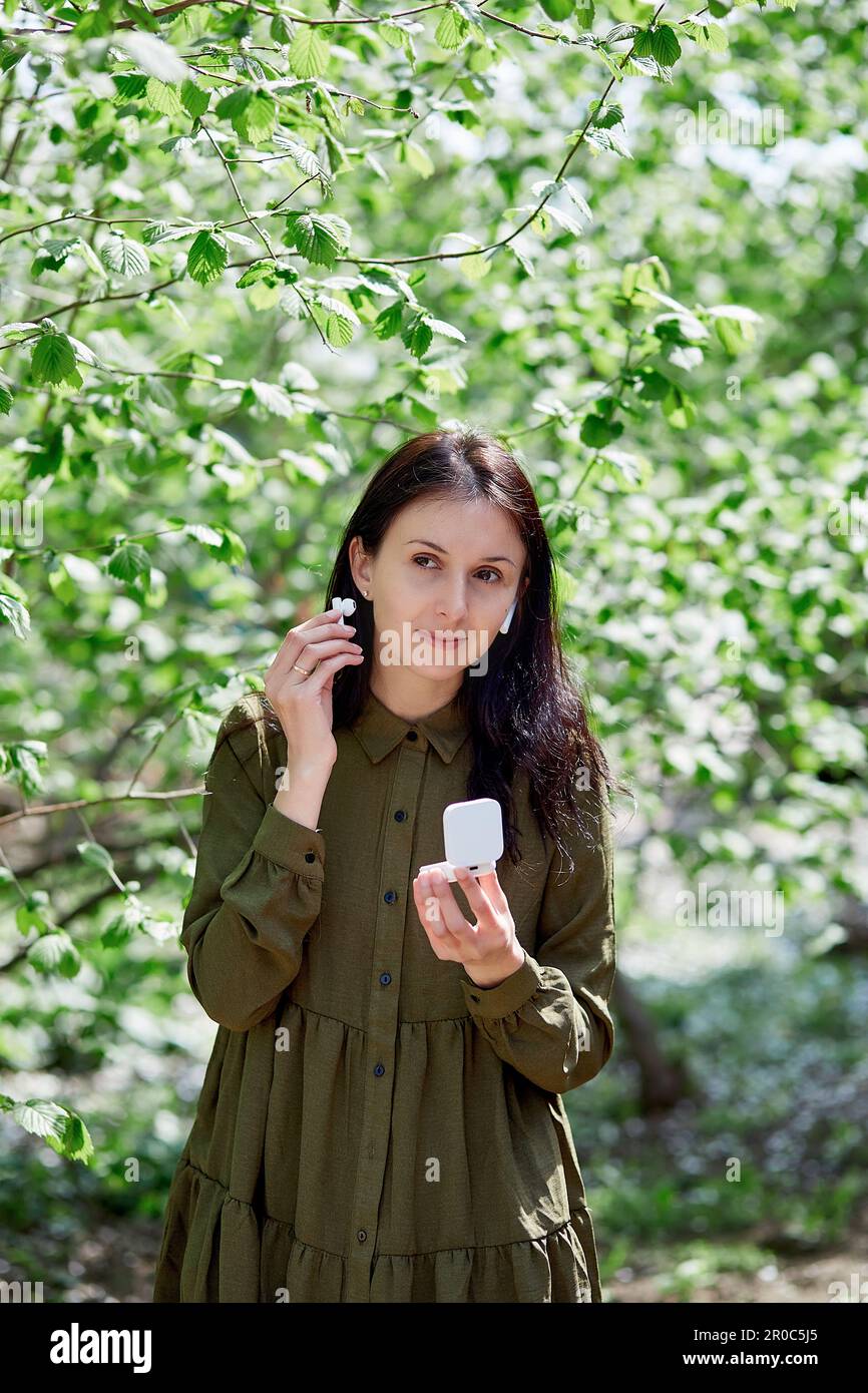 Giovane donna che usa le cuffie, ascolta musica, incontri online o chattare con gli amici, ascolta il corso online. Foto Stock