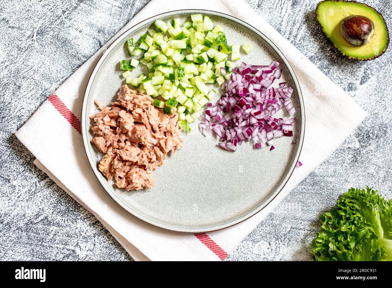 Passaggio 4. Preparazione graduale di un panino con tonno, avocado, cetriolo e cipolla Foto Stock