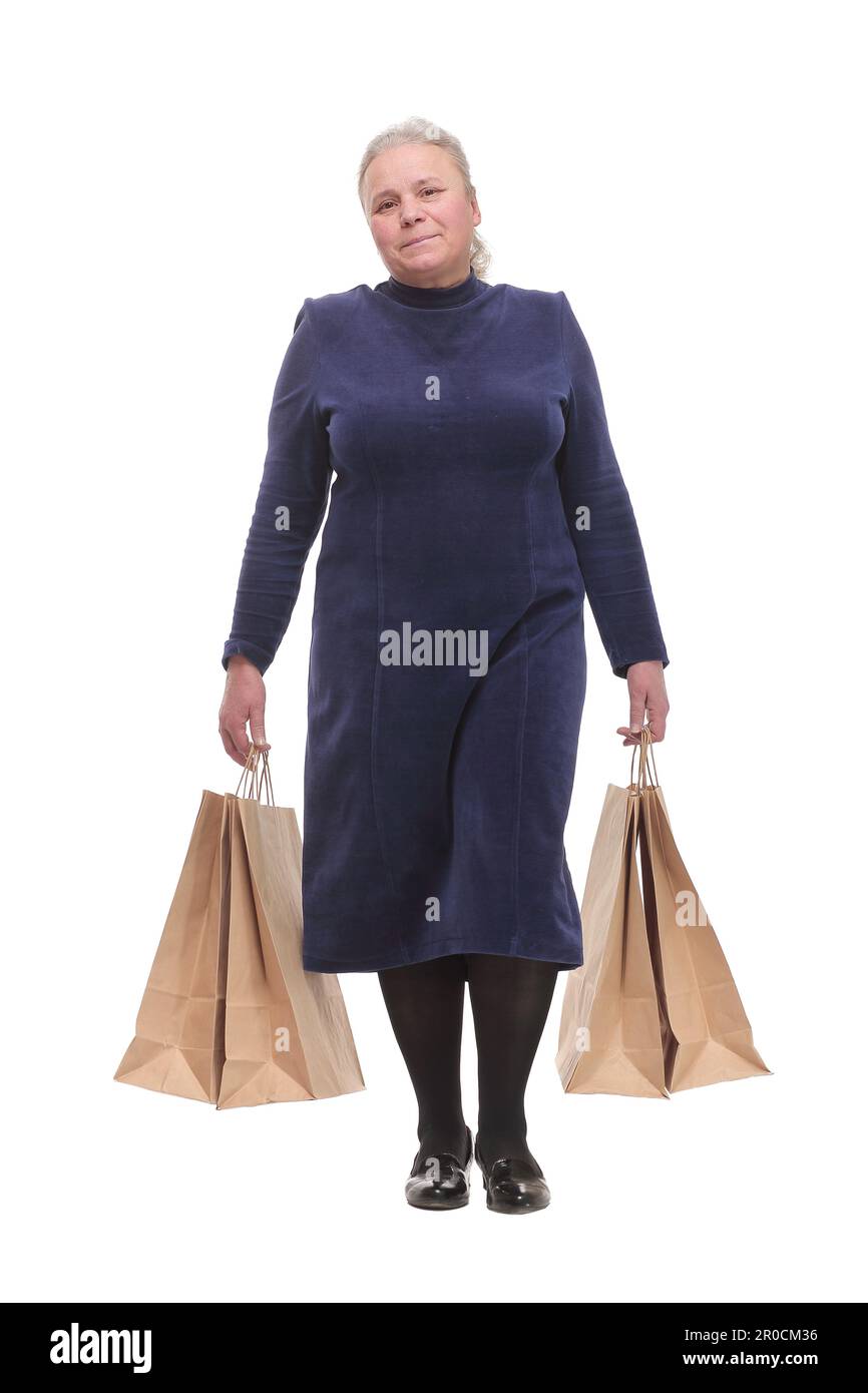 Donna caucasica anziana che cammina con borse per lo shopping sorridente al telespettatore Foto Stock