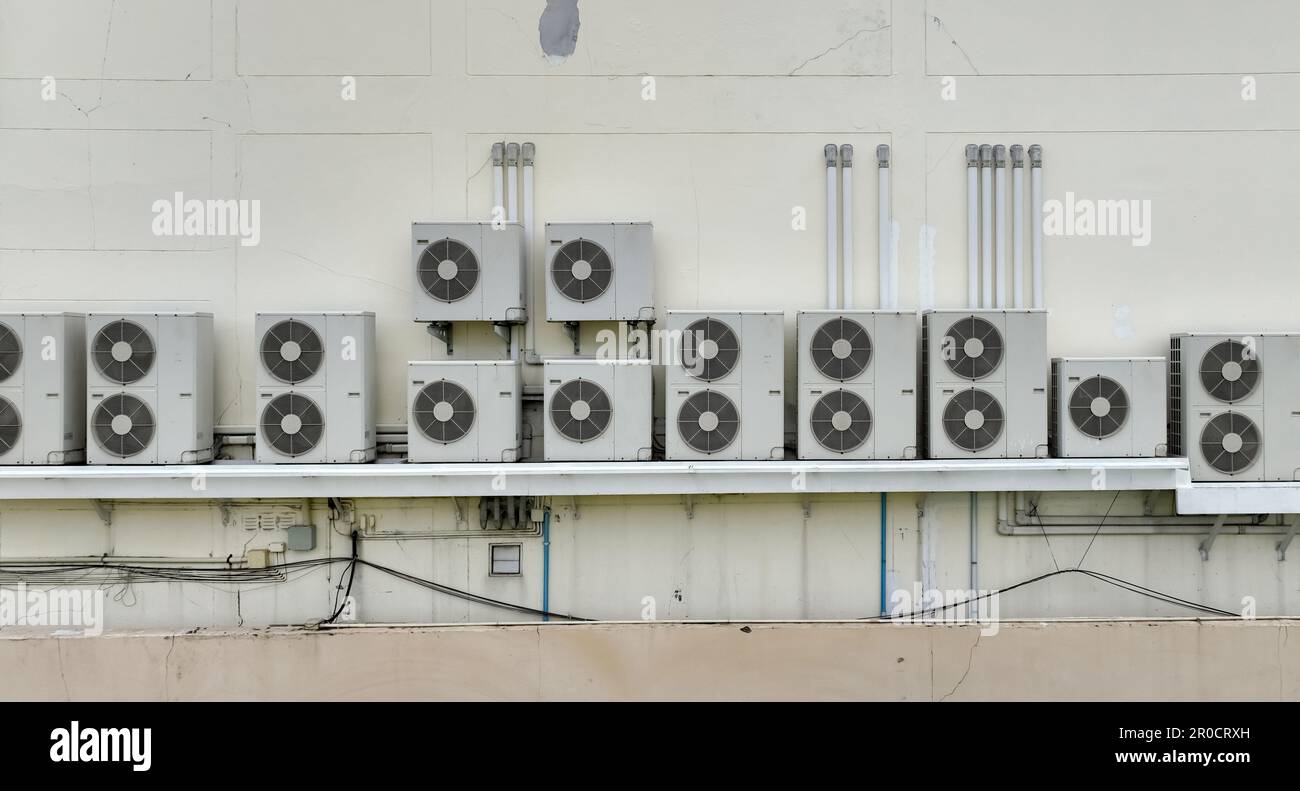Molte unità condensatrici di condizionatori d'aria sono installate su pareti di edifici in cemento. Servizio di manutenzione e riparazione del climatizzatore a casa o in ufficio. Foto Stock