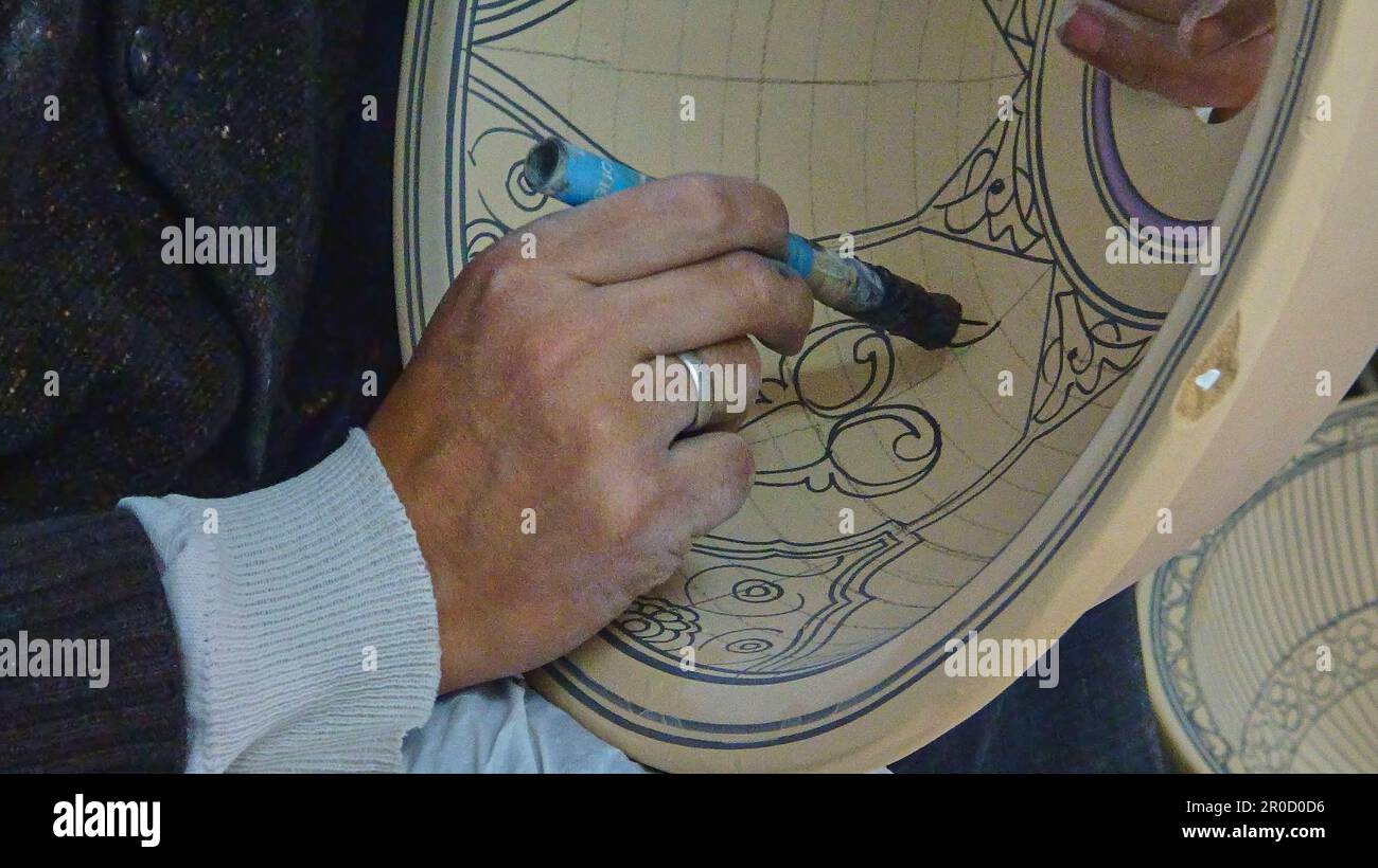 Artigiano dipingere un disegno ornamentale in stile arabo su una terrina in ceramica fatta di argilla, in Marocco. Foto Stock