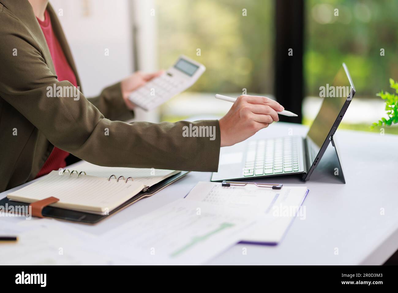 Concetto di business ufficio donna che lavora, Closeup businesswoman che controlla il suo piano di investimento con l'analisi di documenti e dati grafici di investimento aziendale Foto Stock