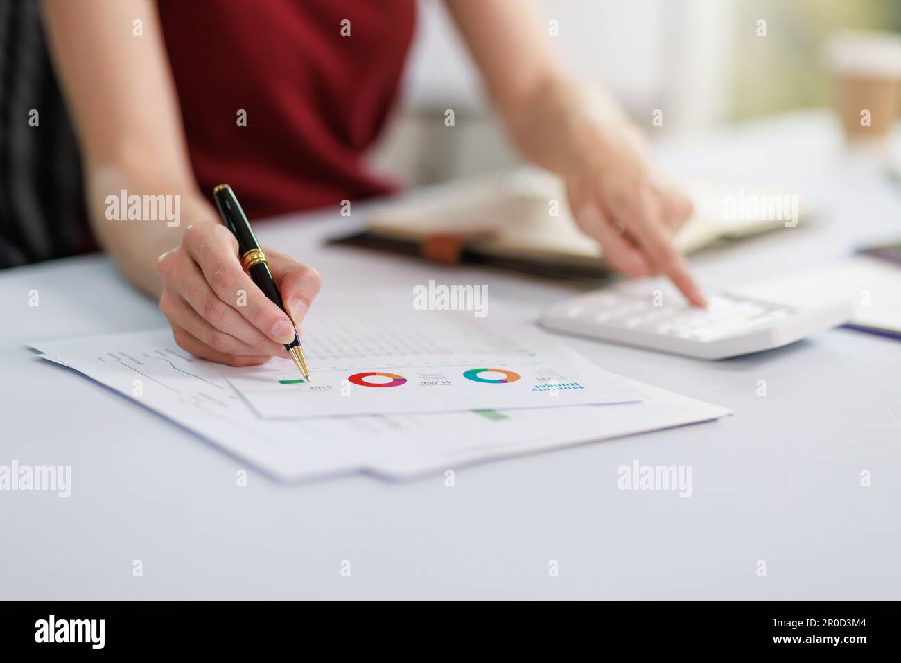 Concetto di business ufficio donna che lavora, Closeup businesswoman che controlla il suo piano di investimento con l'analisi di documenti e dati grafici di investimento aziendale Foto Stock