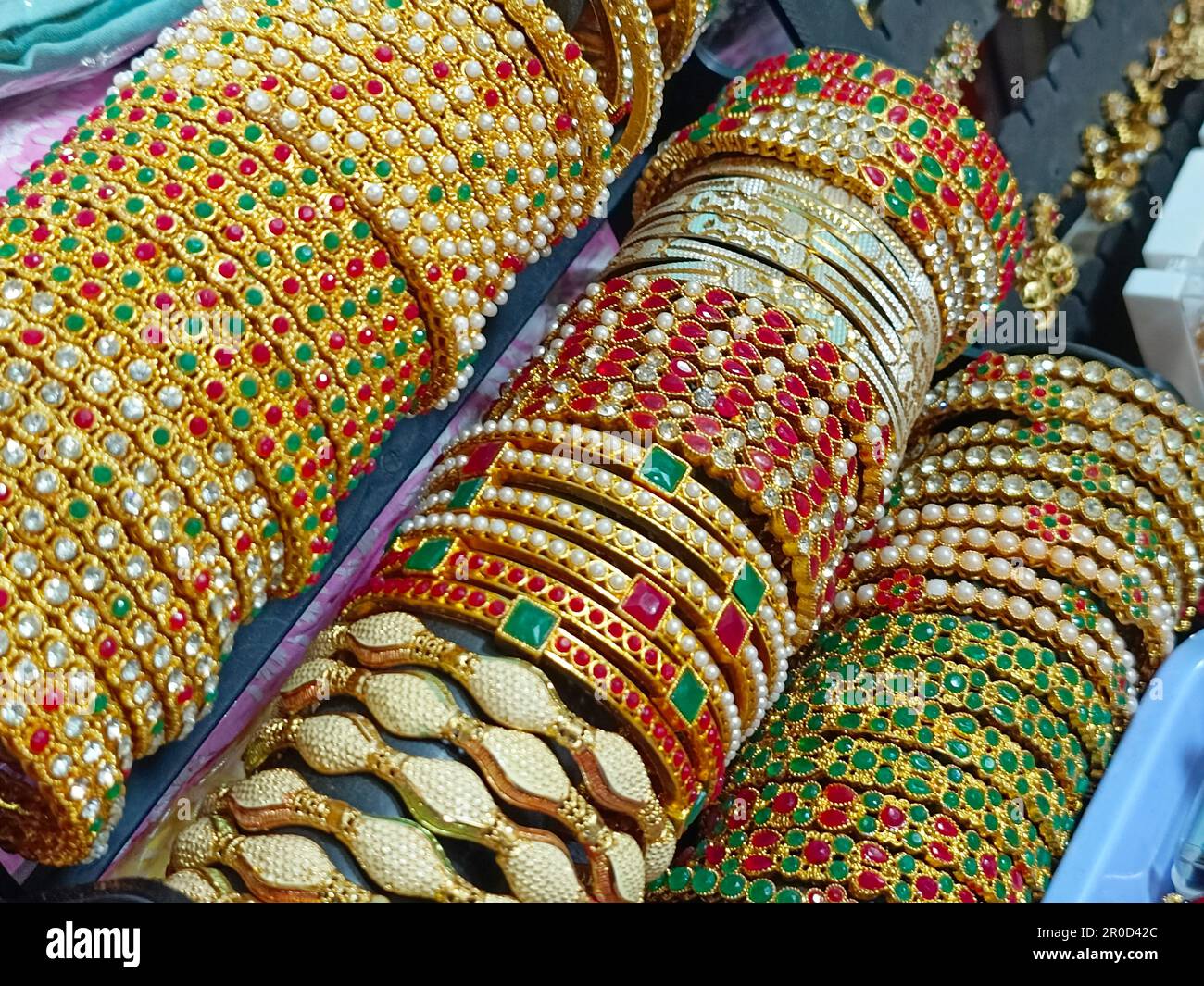 Golden Bangles mostra in negozio per le donne, metallo Bangles disposti sul ripiano per la vendita, serie di bracciali. Messa a fuoco selettiva. Foto Stock