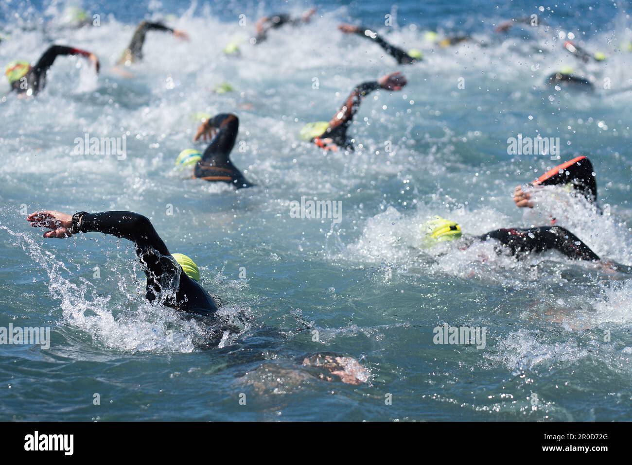 Gli atleti di nuoto in una gara di triathlon nel mare.gli uomini nuotatori strisciano in mare blu, corsa per il triathlon Foto Stock