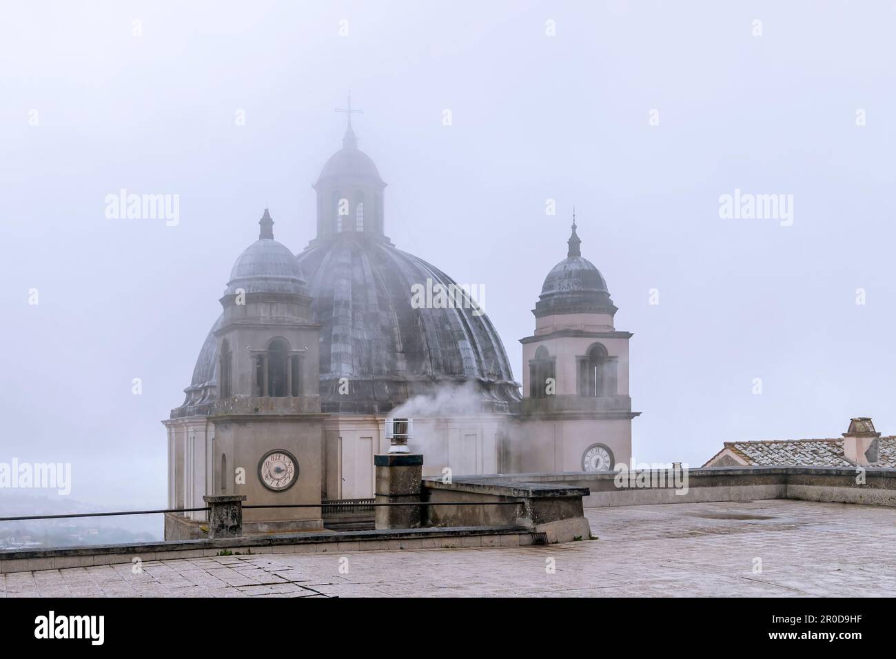La cima del Duomo di Santa Margherita, centro storico di Montefiascone, Italia, nella nebbia di una giornata piovosa Foto Stock