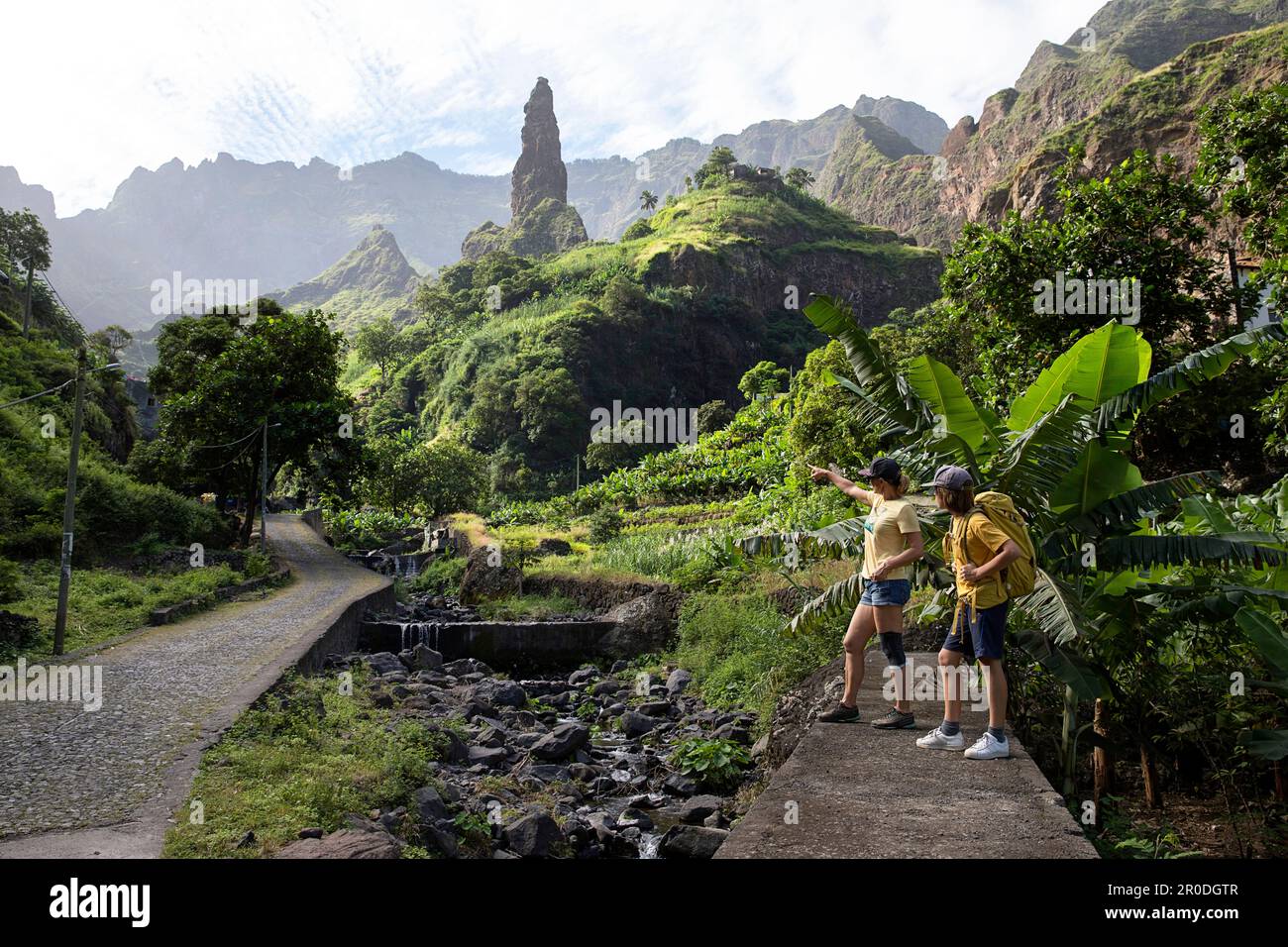 Madre e figlio, turisti che guardano il bellissimo villaggio xoxo sotto la colonna di roccia nel verde, lussureggiante ribeira grande valle, santo antao, cabo verde Foto Stock