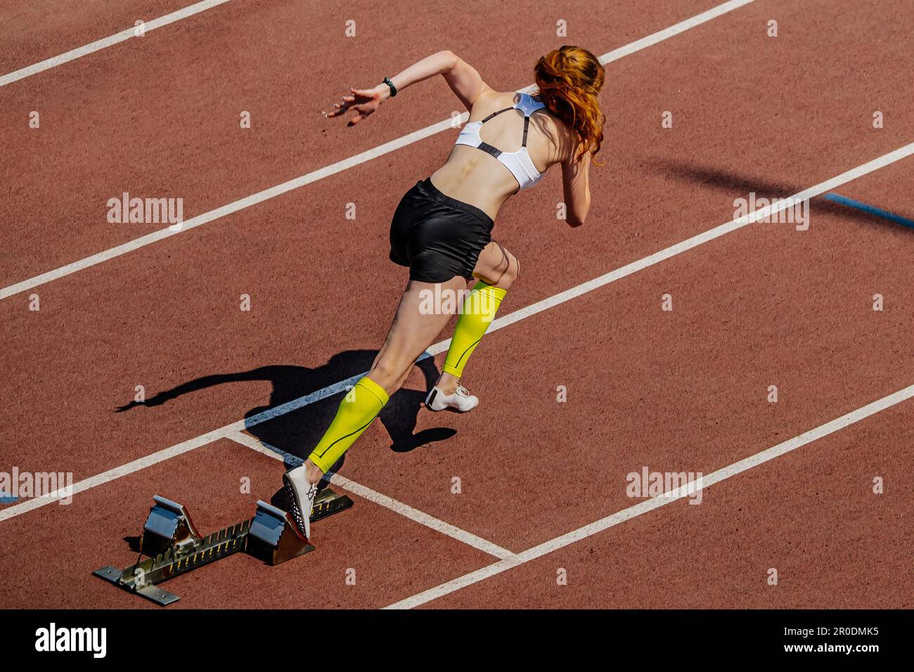 il velocista femminile inizia a correre dai blocchi di partenza nei campionati estivi di atletica Foto Stock
