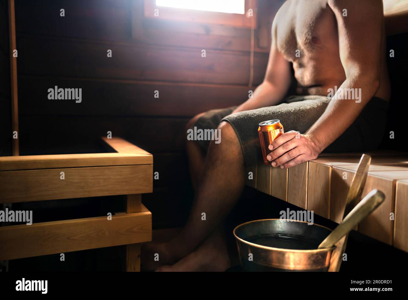 Sauna e birra. Uomo nel bagno turco che si rilassa e beve un drink. Tradizionale finlandese di legno scuro salute spa casa o in hotel benessere in Finlandia. Foto Stock