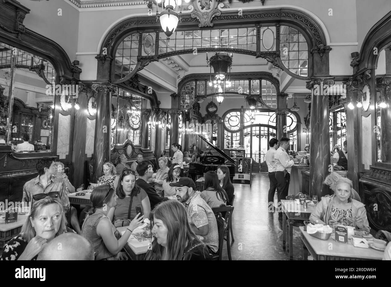 Porto, Portogallo - 4 maggio 2023: La gente gode lo stile, la torta e l'interno del caffè Majestic a Porto. Foto Stock