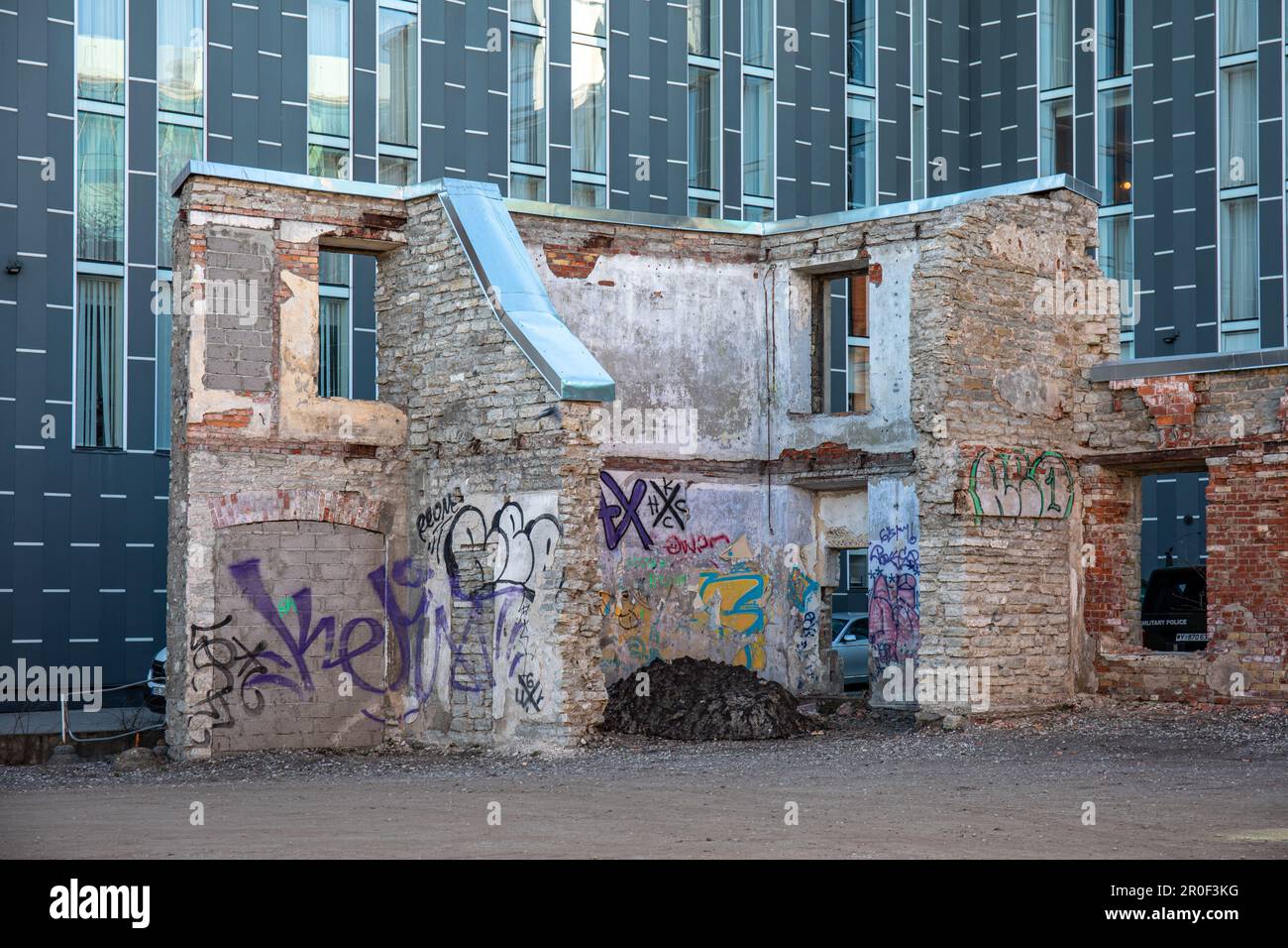 Rovine di un vecchio edificio industriale sullo sfondo di un moderno edificio commerciale nel quartiere Rotermanni di Tallinn, Estonia Foto Stock