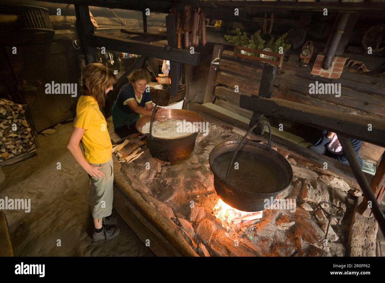 Anna Gruber spiega la produzione tradizionale di formaggio donna su camino aperto, Karseggalm (1603 m, uno dei più antichi rifugi della valle), Gro Foto Stock