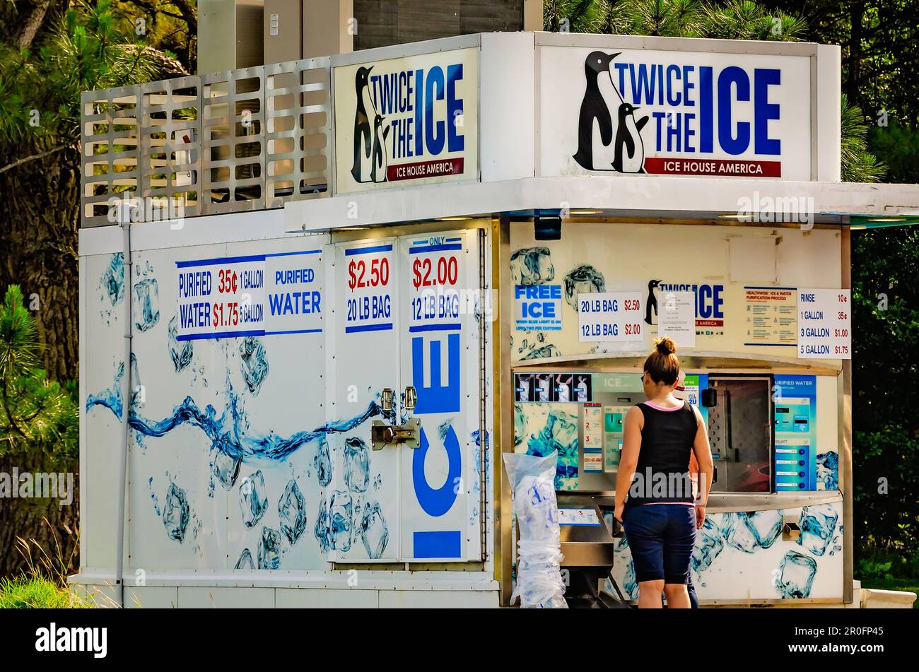 La gente ottiene i sacchetti di ghiaccio da due volte il ghiaccio, un distributore automatico di ghiaccio, 2 maggio 2023, a Bayou la Batre, Alabama. Foto Stock