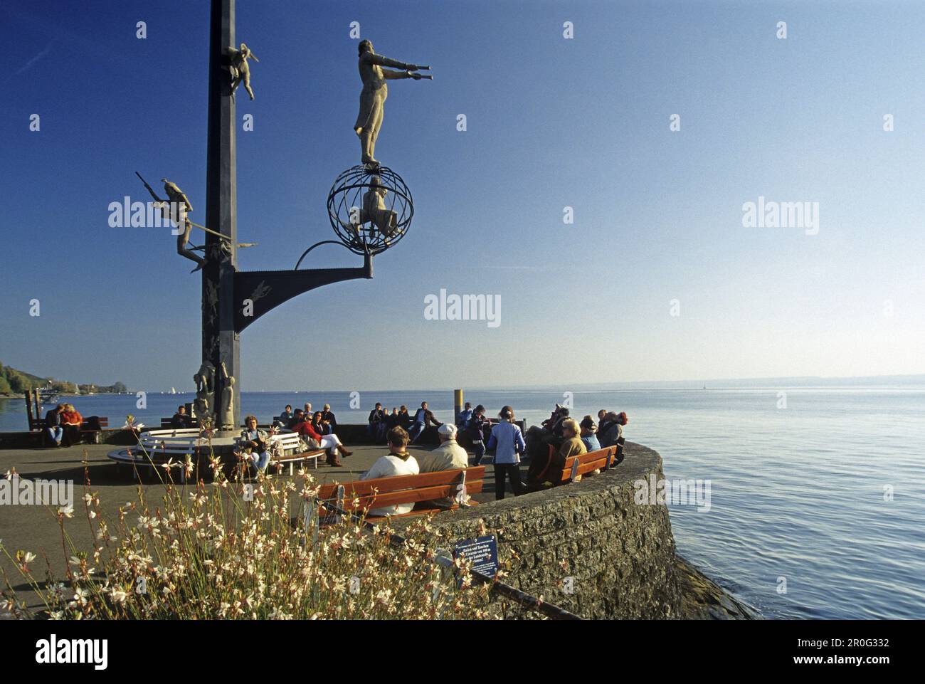 Sculture e persone sul lungomare alla luce del sole, Meersburg, Lago di Costanza, Baden Wurttemberg, Germania Foto Stock