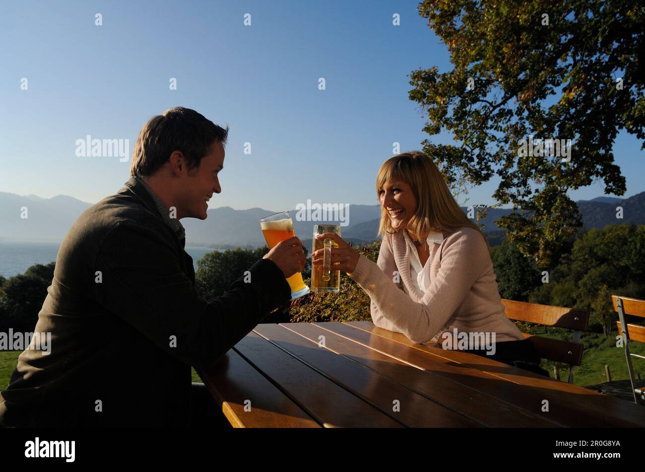 Coppia giovane in un giardino della birra sotto la luce diretta del sole, il lago Tegernsee, Baviera, Germania, Europa Foto Stock