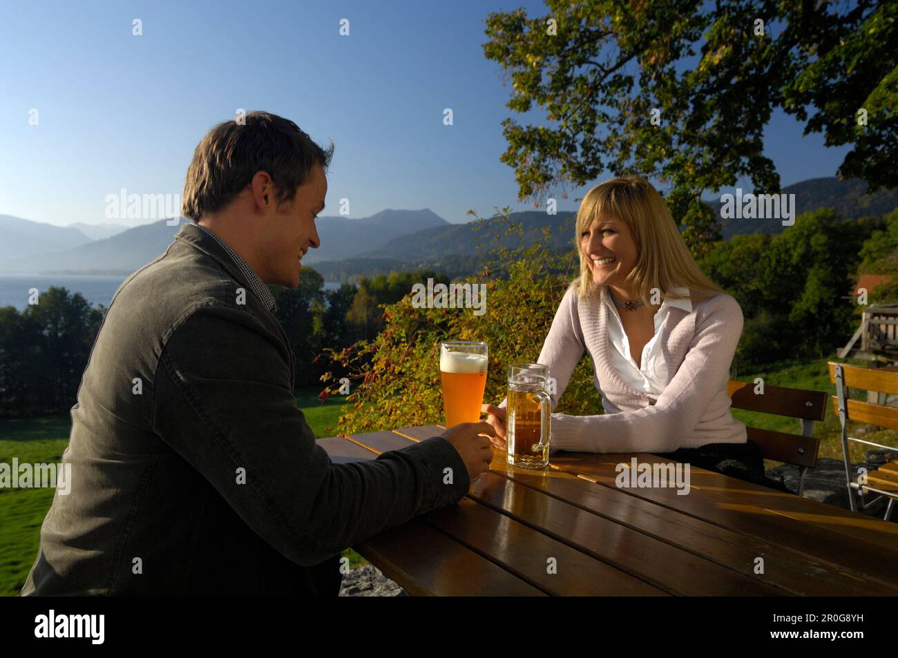 Coppia giovane in un giardino della birra sotto la luce diretta del sole, il lago Tegernsee, Baviera, Germania, Europa Foto Stock