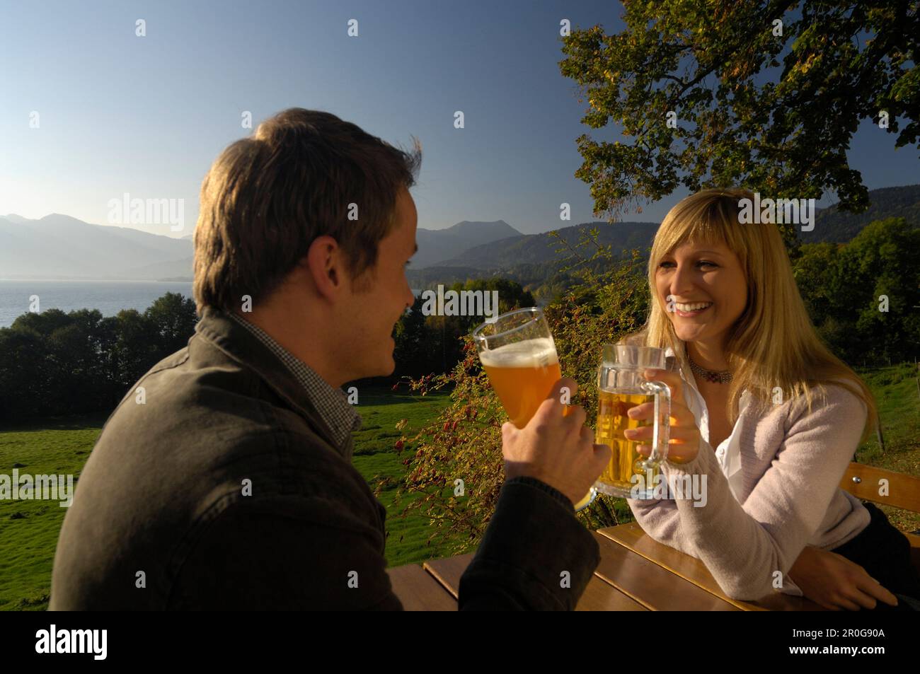 Coppia giovane in un giardino della birra sotto la luce diretta del sole, il lago Tegernsee, Baviera, Germania, Europa Foto Stock