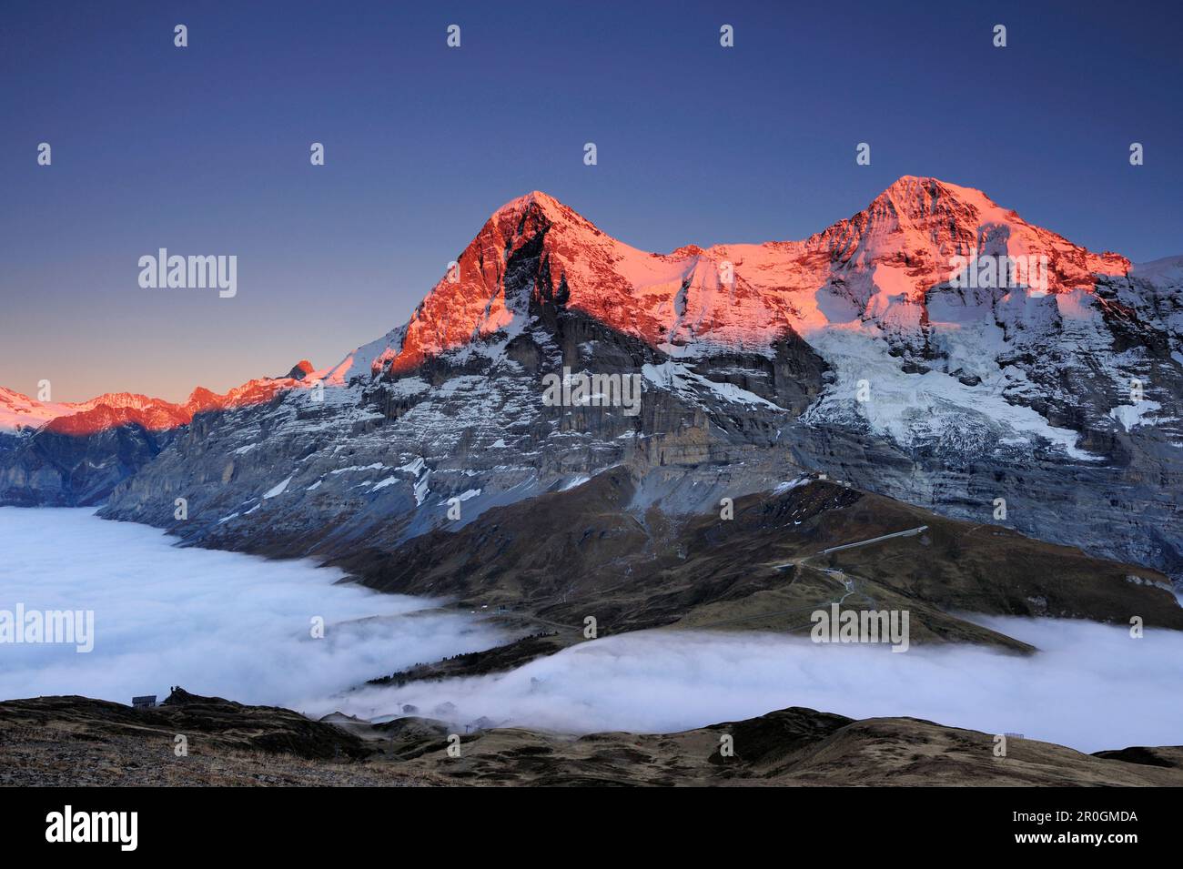 Alpenglow a Eiger e Moench sopra Kleine Scheidegg, mare di nebbia sopra Grindelwald, Kleine Scheidegg, Grindelwald, patrimonio dell'umanità dell'UNESCO, Svizzera al Foto Stock