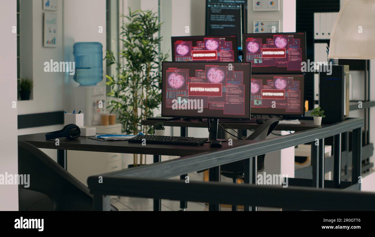 Ufficio IT con più monitor che mostrano messaggi di errore critico lampeggianti sugli schermi, avviso di attacco hacking. Scrivania vuota con computer che mostrano crash del sistema e violazione della sicurezza della rete. Foto Stock
