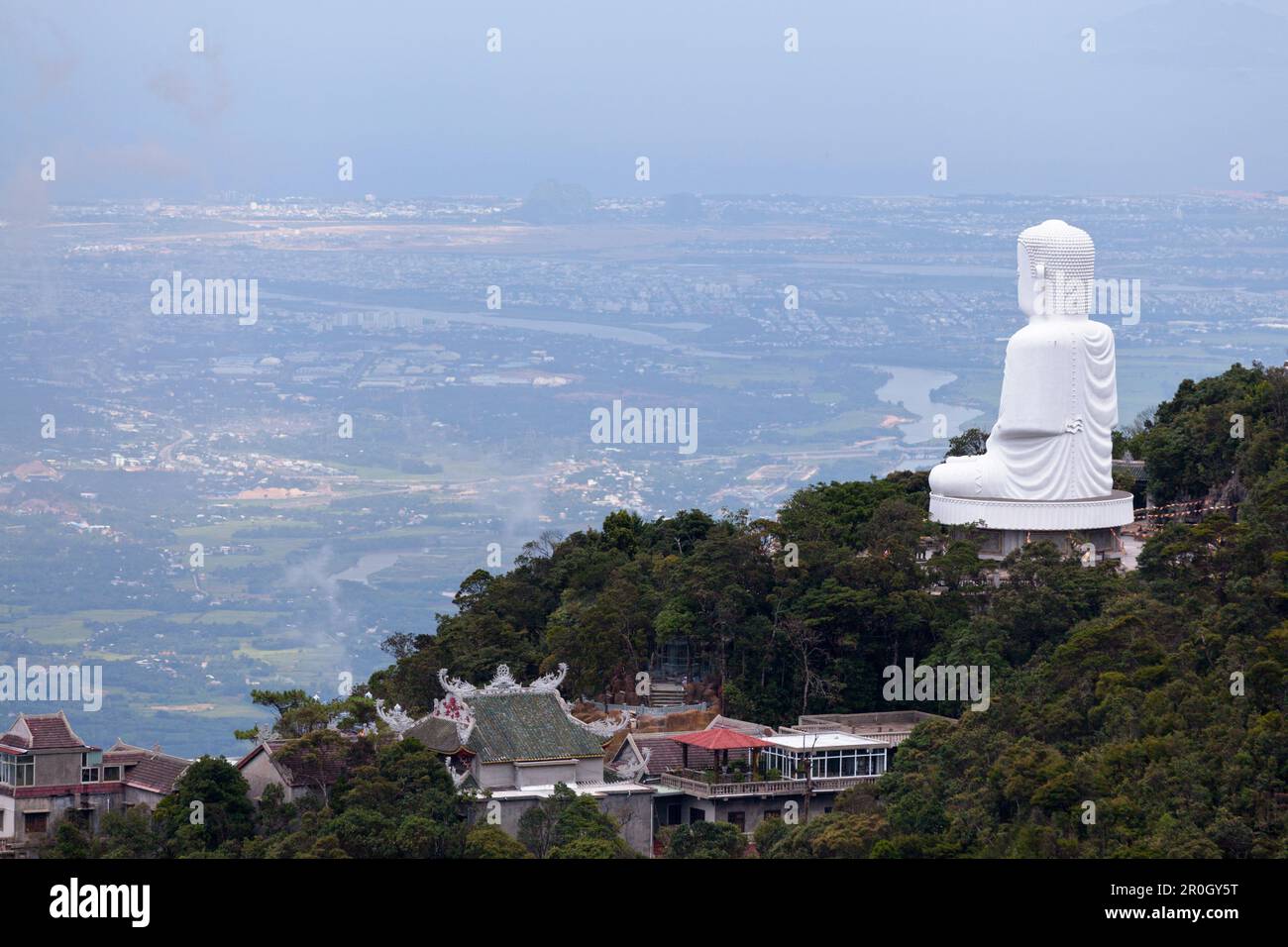 Statua di Buddha bianco che si affaccia da Nang dalla Pagoda di Linh Ung in cima alle colline di Bà Nà in Vietnam. Foto Stock