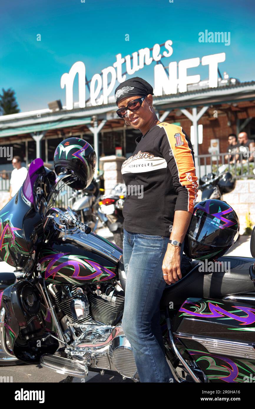 Stati Uniti, California, Malibu, un biker sorge accanto al suo moto di fronte Neptunes Net Ristorante sulla Pacific Coast Highway Foto Stock